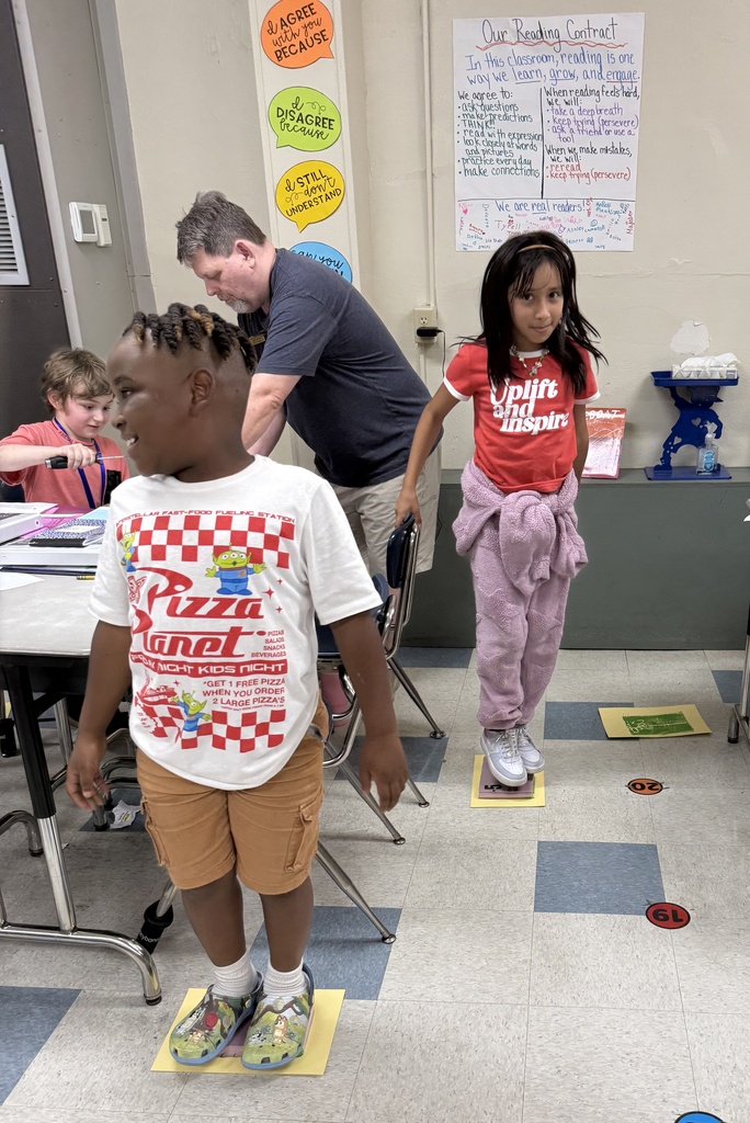 several students standing on foam to make a print with paper and paint