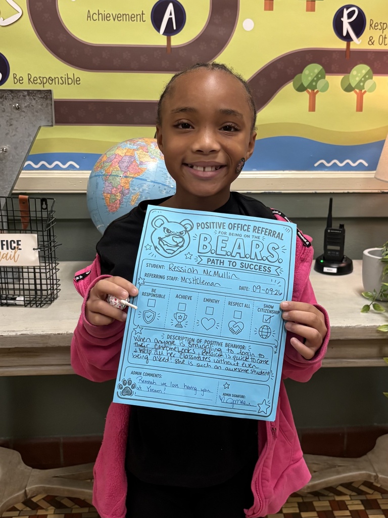student standing with a positive office referral paper