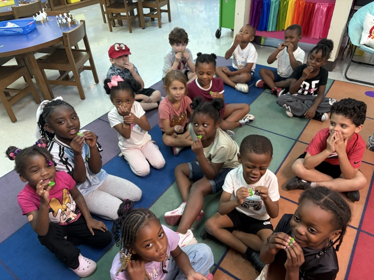 students trying gummy green frogs and making faces about the taste