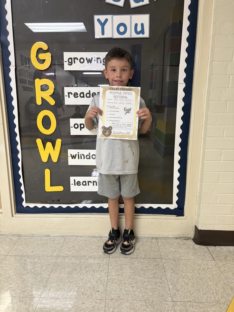 student holding a positive office referral paper