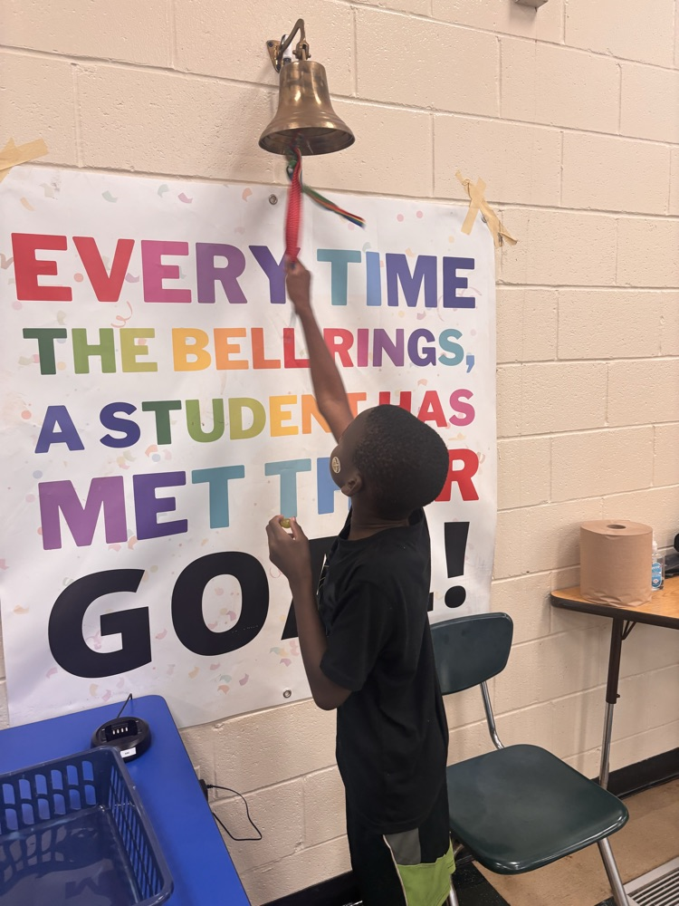boy ringing a bell on a wall