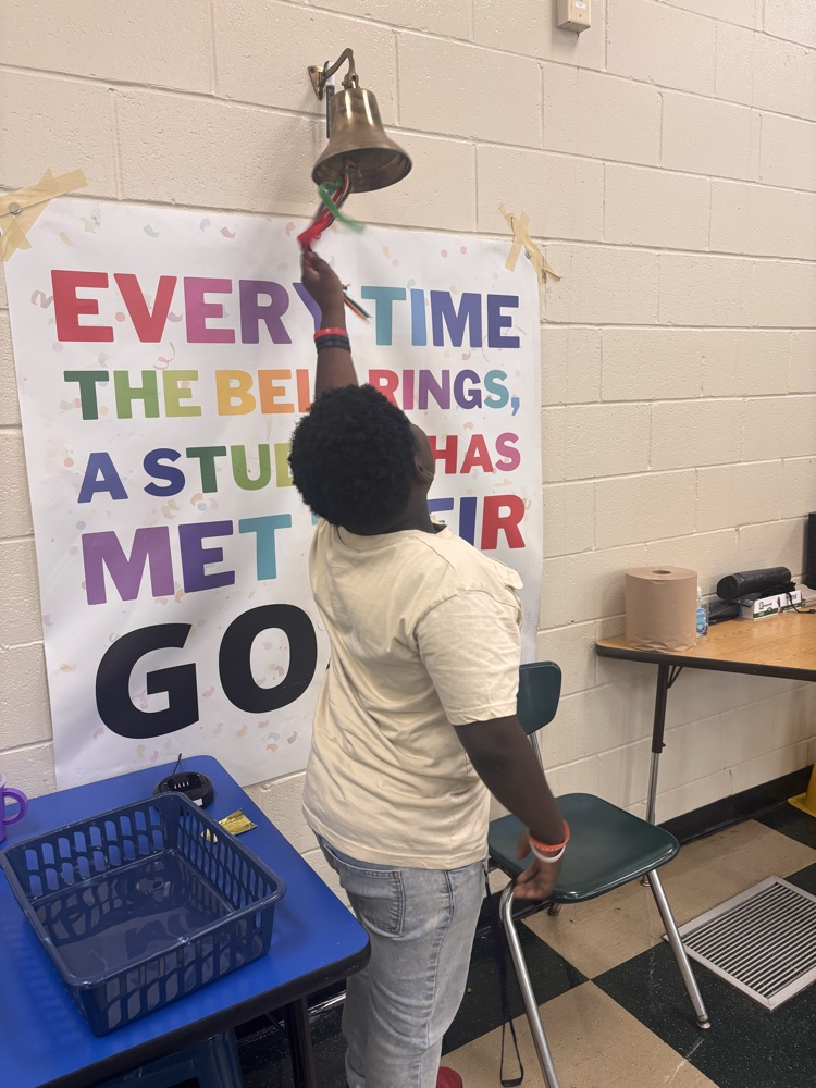 boy ringing a bell on the wall