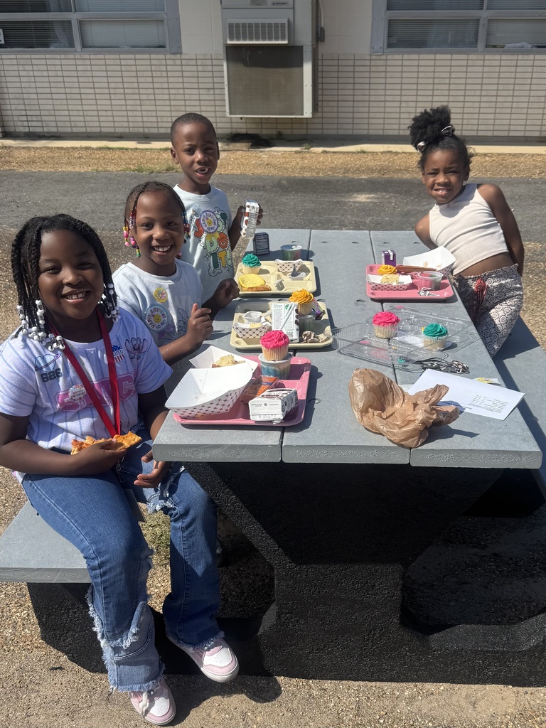 students eating lunch outside on a picnic table