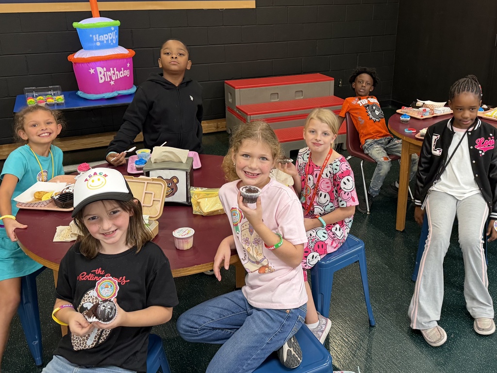 students sitting at tables on the stage eating lunch