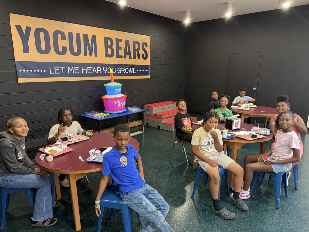 students sitting at tables on the stage eating lunch
