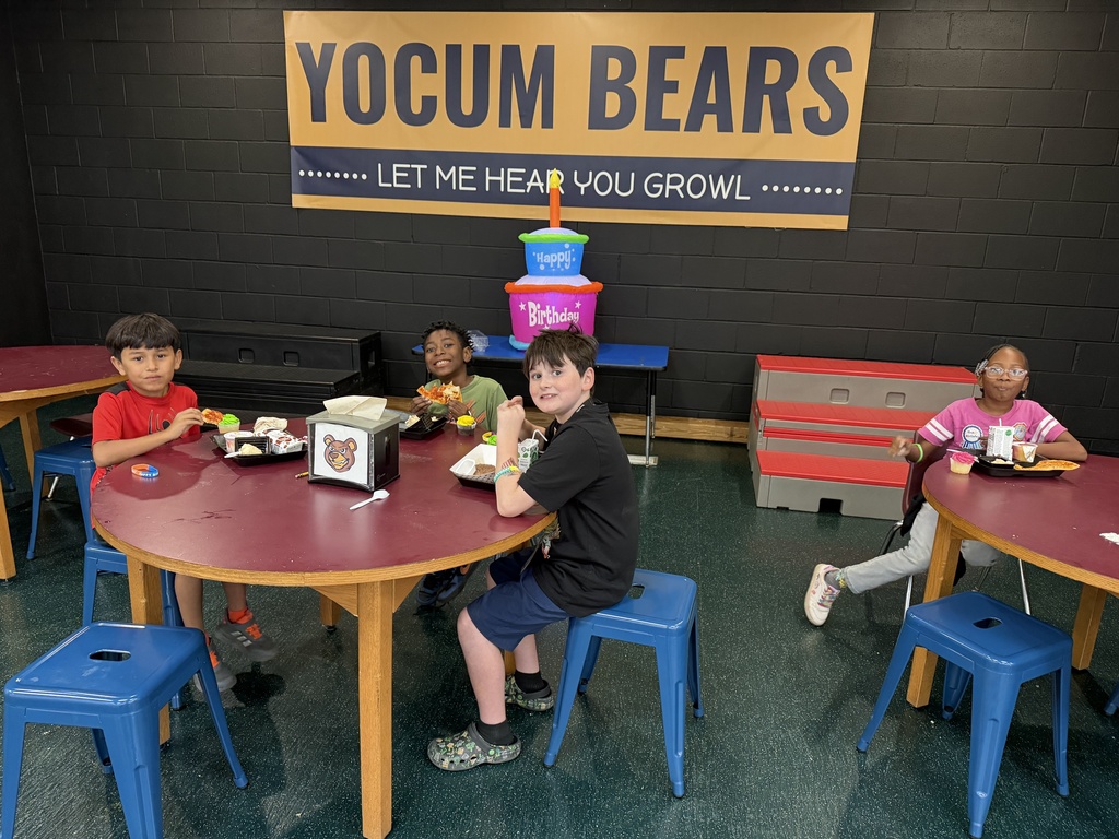 students sitting at tables on the stage eating lunch