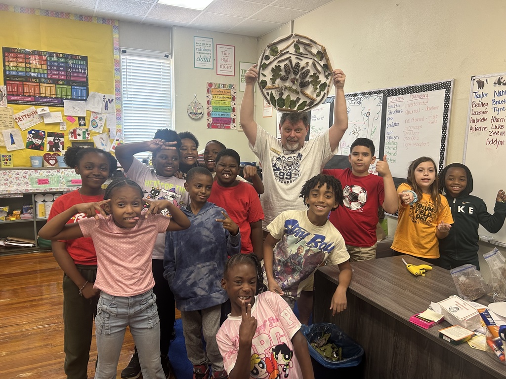 group picture of mr mike with students holding up a nature mandala