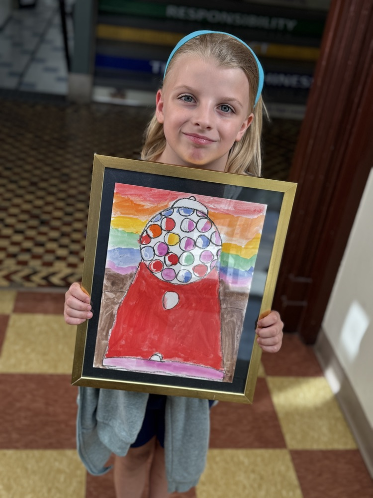 student standing with her painting of a gun ball machine