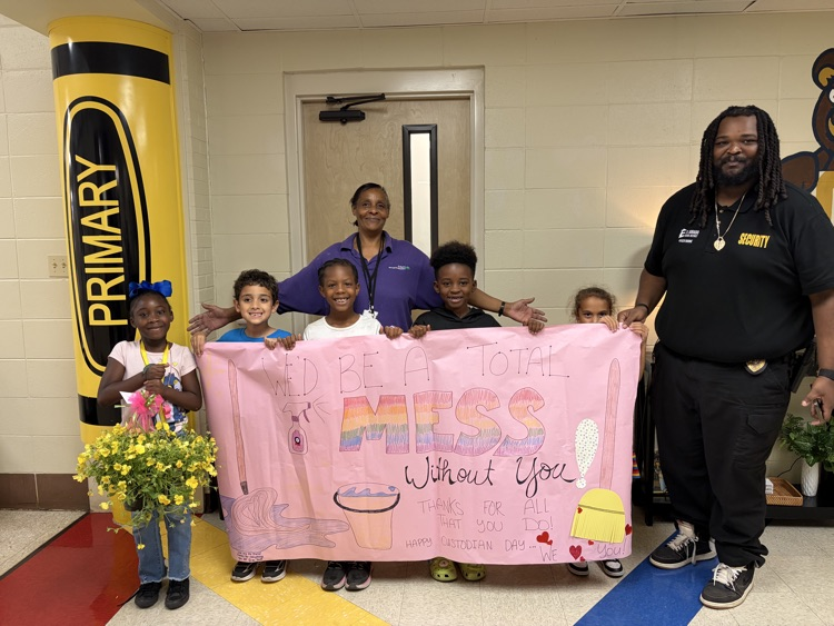 custodian holding a sign and flowers thanking them for their service