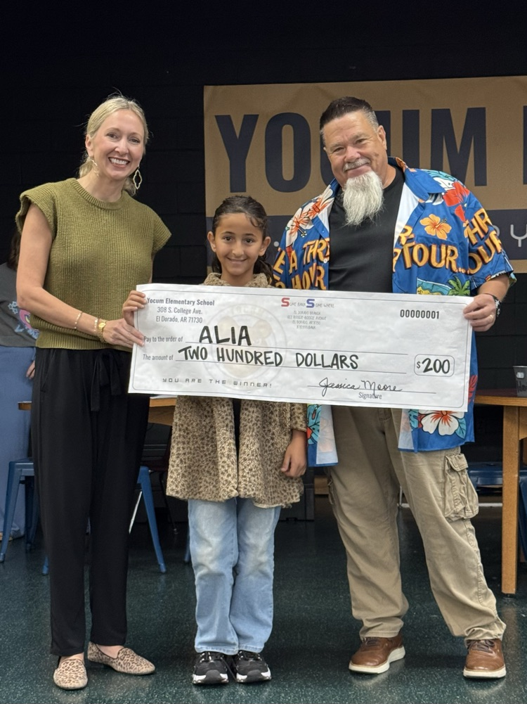 student and two adults holding giant check