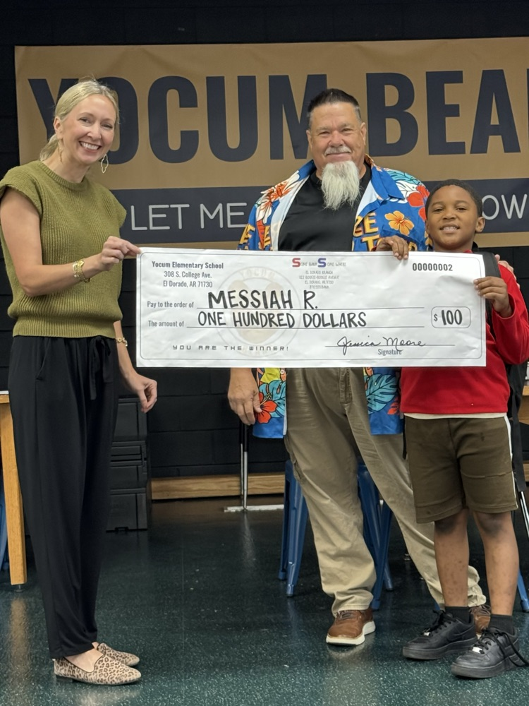 student and two adults holding giant check