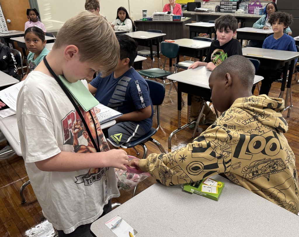 student passing out suckers to other students