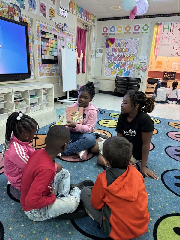 2 fourth grade girls reading to 3 kinders