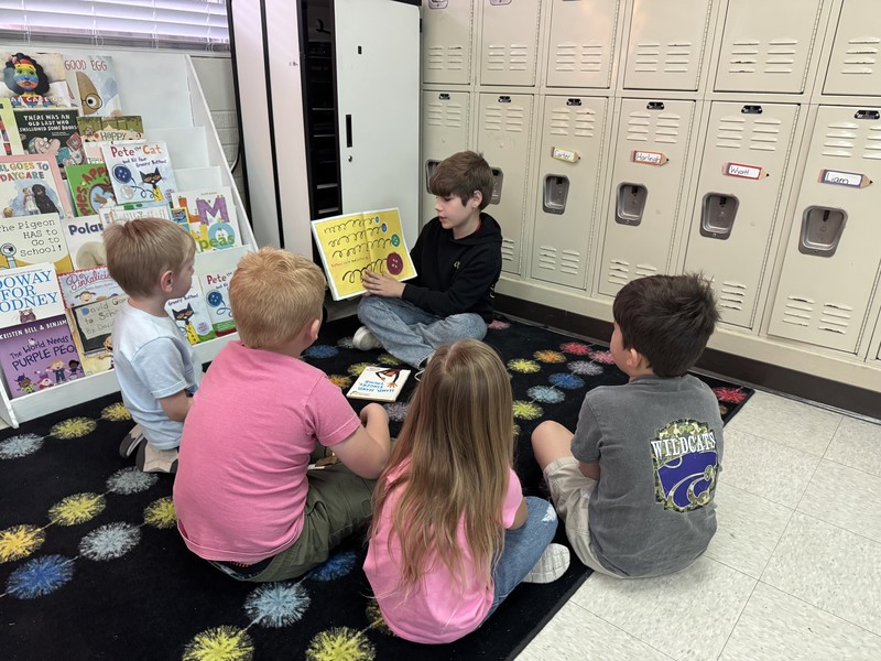 fourth grade boy reading to 4 kinders