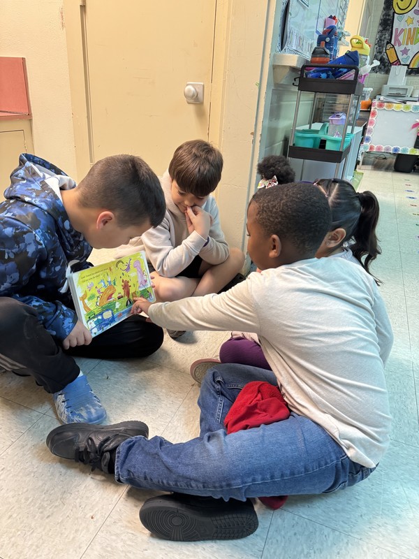 2 boys reading to 3 kinders