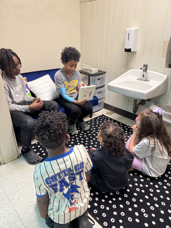 boys reading to 3 kinders