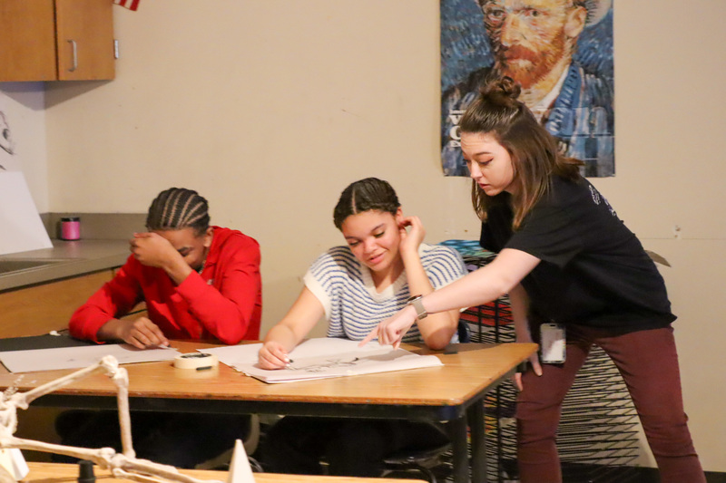 teacher guiding students drawing