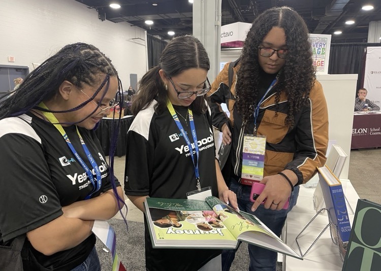 students reading a yearbook at the Nashville journalism Convention