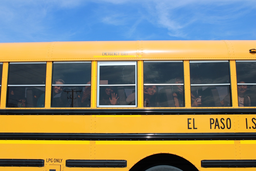 Students looking out the window of a school bus.