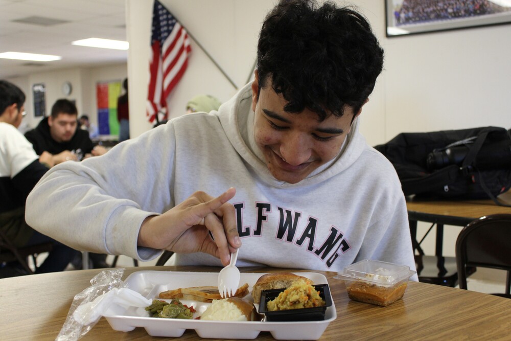 A student eats lunch in the cafeteria.