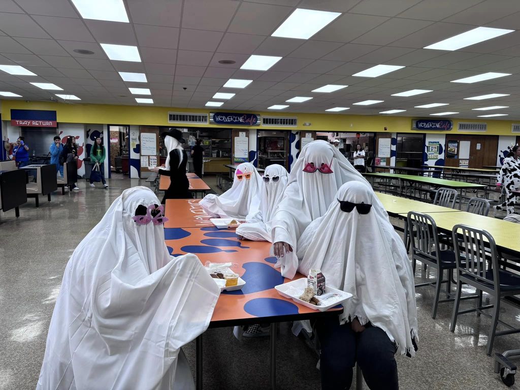 Wiggs staff dressed as ghosts sitting in a cafeteria
