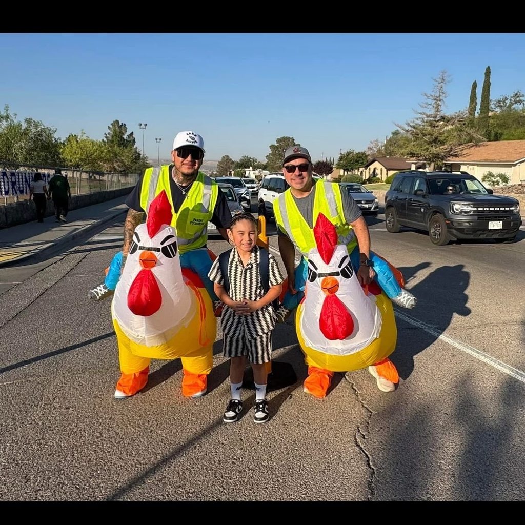 Western Hills Volunteers in Public Schools community members monitor traffic for student safety in inflatable chicken suits