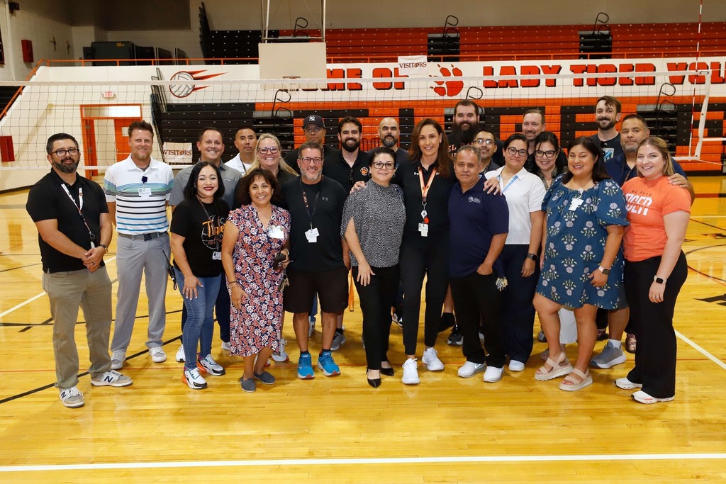 Coach Alarcon takes a photo with staff