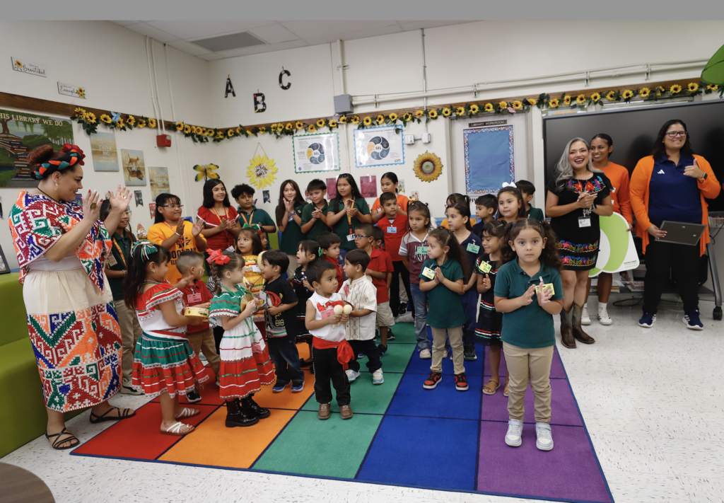 Group photo of Douglass Elementary students and staff with representatives from UTEP Athletics