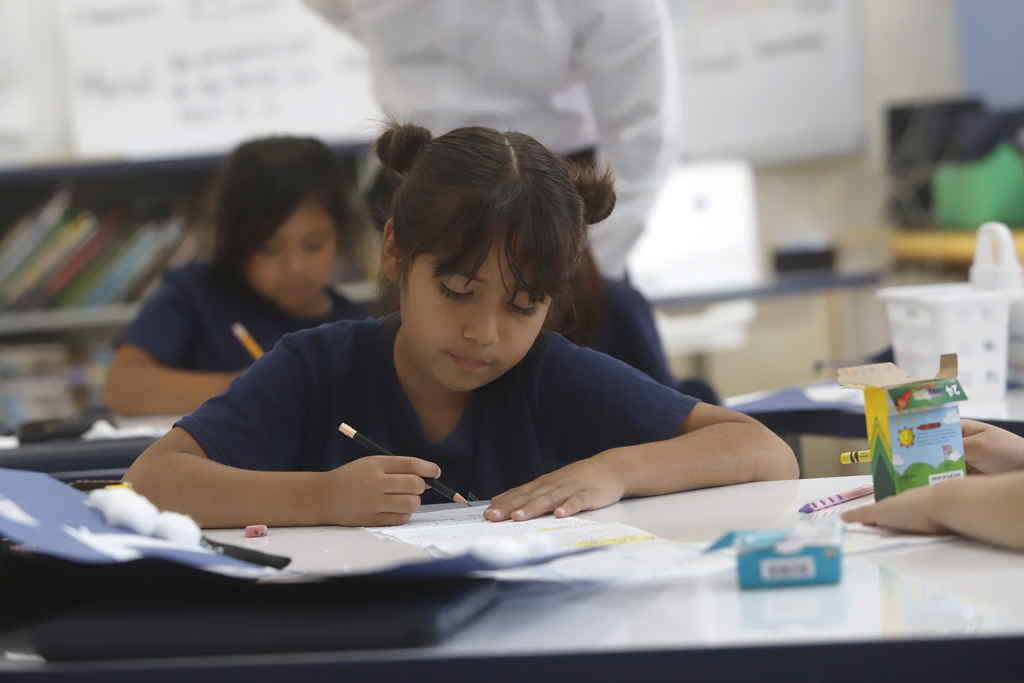 Student writing on paper