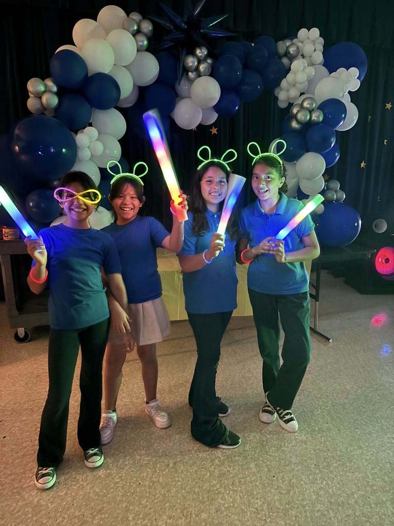 Hawkins students smiling with glow sticks and glow ears