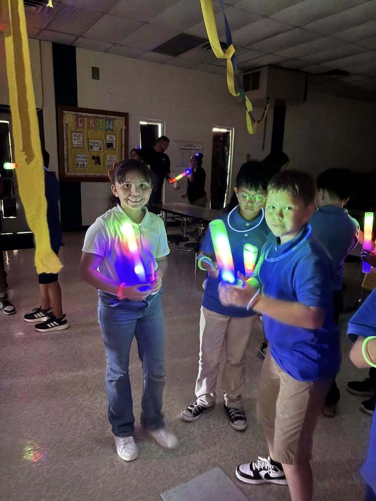Hawkins students smiling with glow sticks