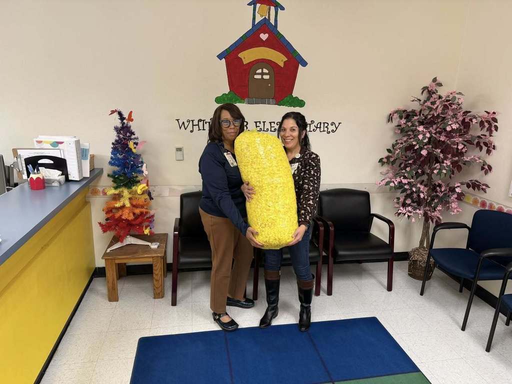 Whitaker Elementary principal and staff member holding large bag of popcorn