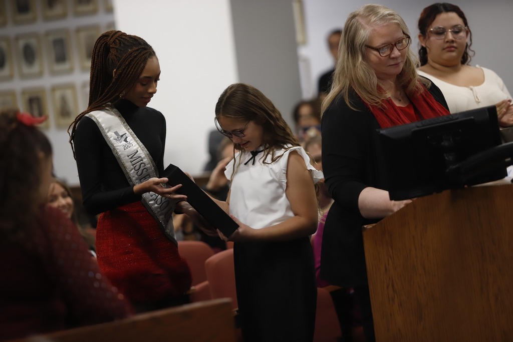 Sophia Salas receiving her certificate for earning 1st place in the "Future Voter" Sticker Design Contest