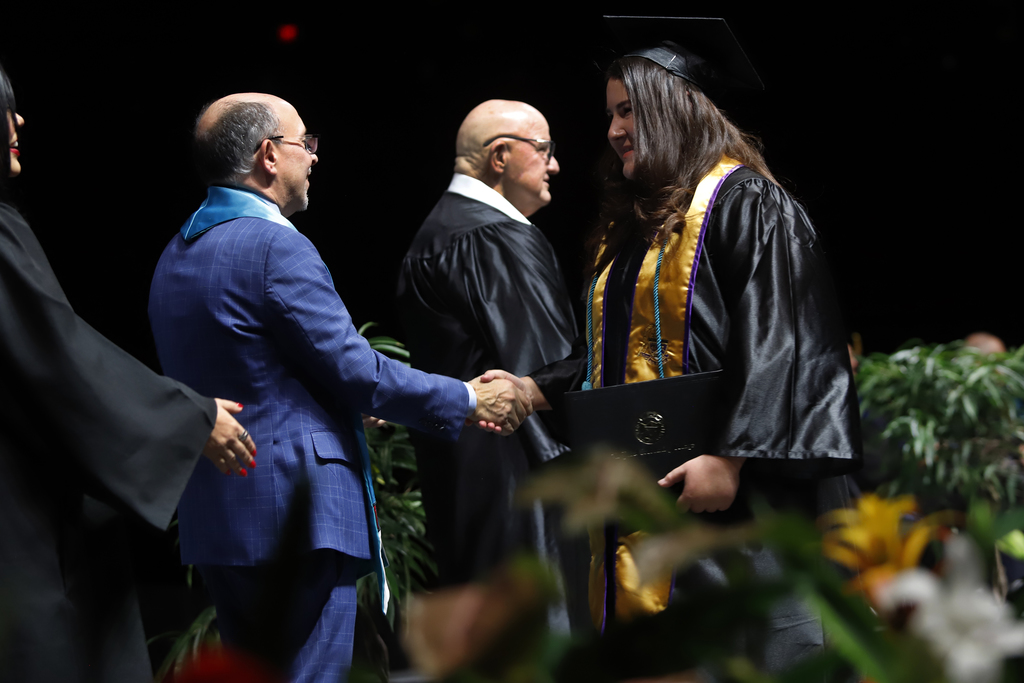 Burges Early College High School student shakes hands after receiving diploma