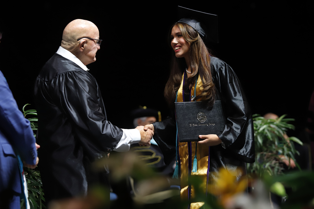 Burges Early College High School student shakes hands after receiving diploma