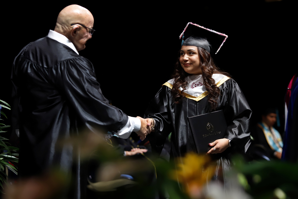 Andress High School's Sophia Villegas shakes hand with EPCC staff after receiving diploma