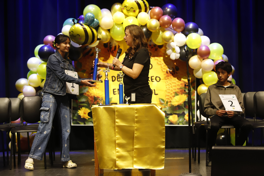 Shaheli De Silva, Young Women's STEAM Prep Academy receiving a trophy at the district spanish spelling bee