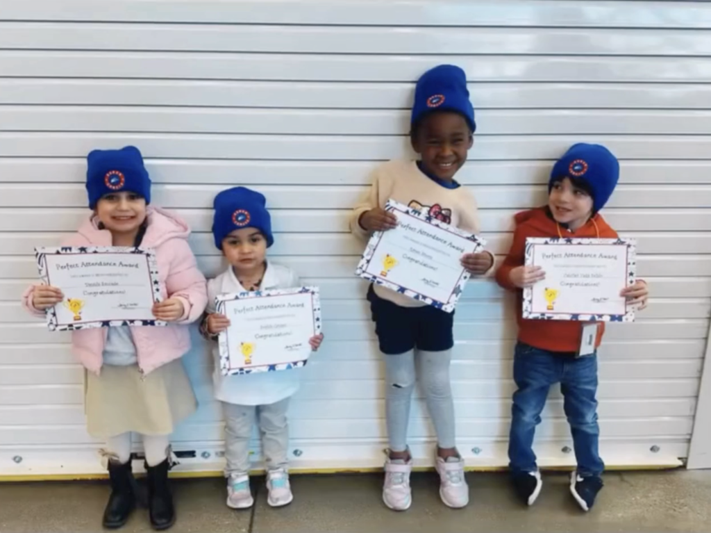 Duran Elementary School students celebrate perfect attendance with certifications and new campus beanies while taking a group photo