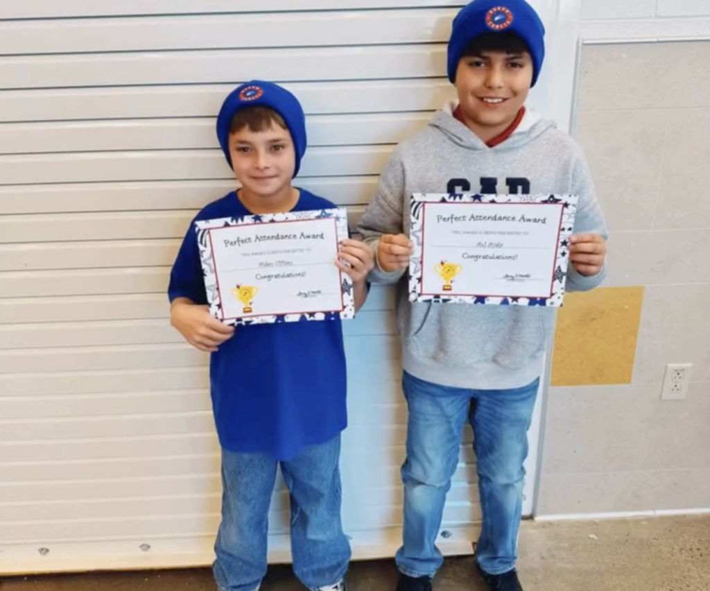 Duran Elementary School students celebrate perfect attendance with certifications and new campus beanies while taking a group photo