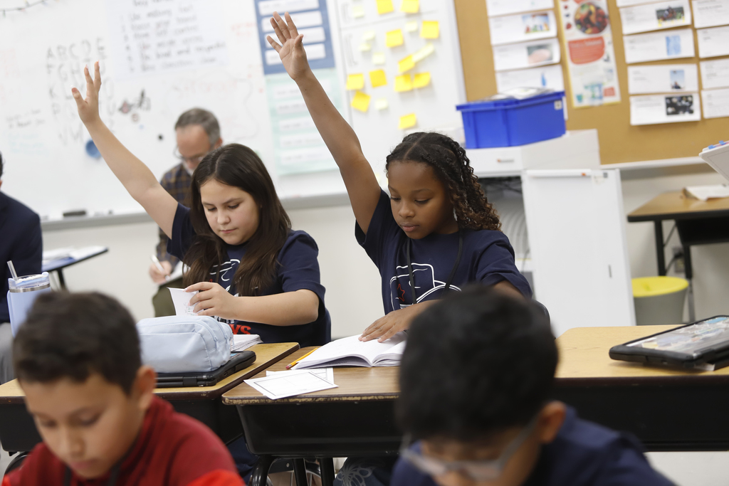 Zach White Elementary School students raising their hands