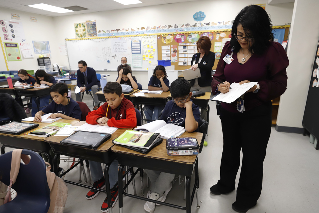 Zach White Elementary School students learning in the classroom while staff and superintendent observe