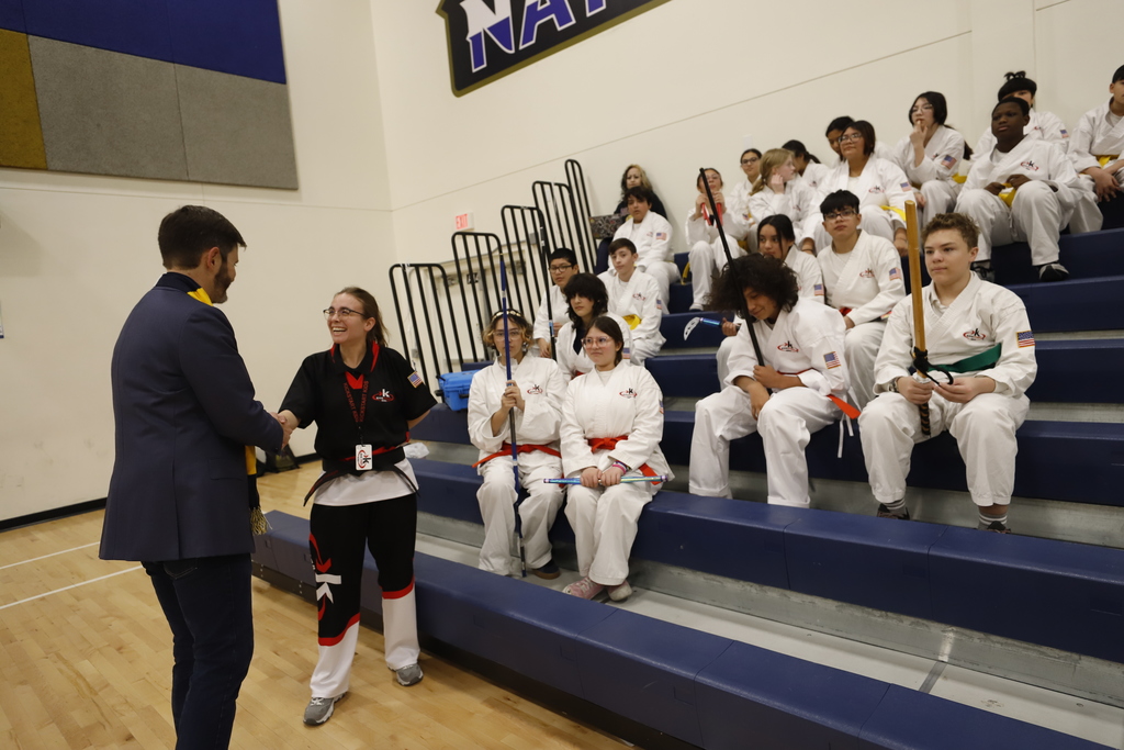 Dr. Jack Loveridge shakes hand with Navarette Middle School Kick Start program instructor as student watch behind