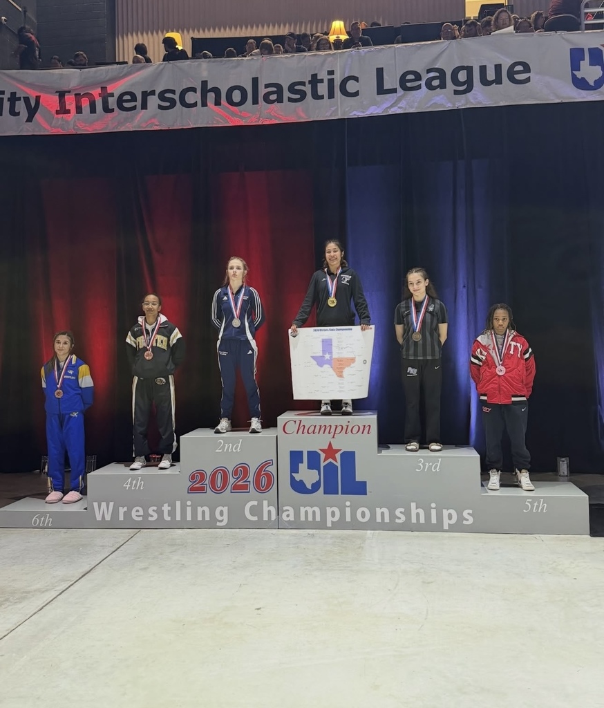 Franklin High School Senior Jubilee Rendon smiles for a photo on podium with other Wrestling State Placers. She is sitting on in the 1st place section as she won state champion