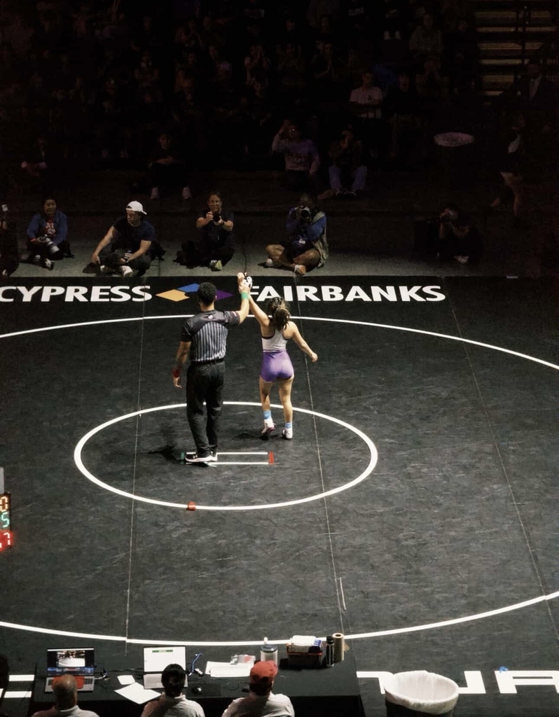 Ref raising Jubilee Rendon's arm after her win at the State Wrestling Tournament
