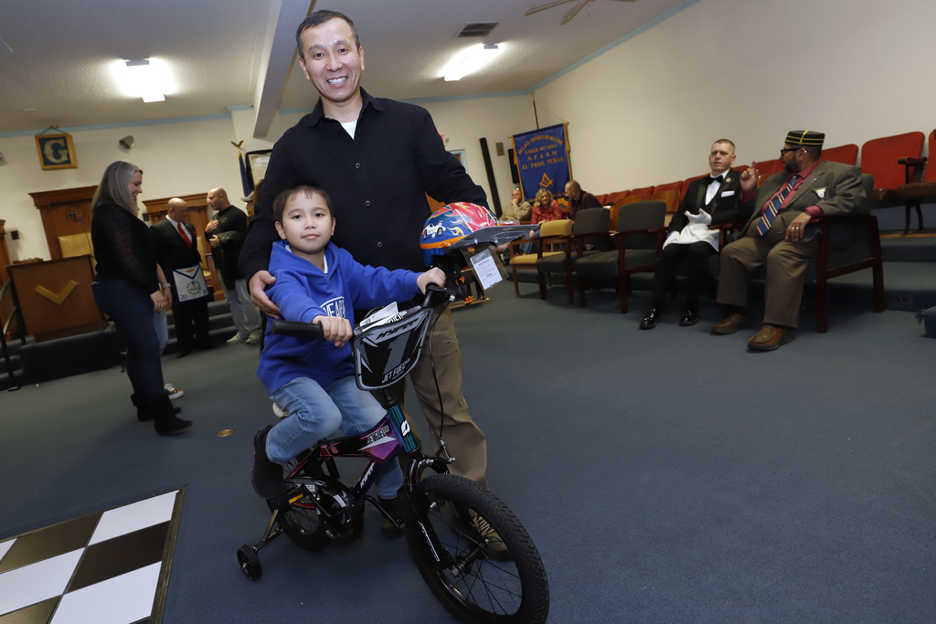 Student and parent take photo with new bike at the DODEA Bicycle Donation Dinner