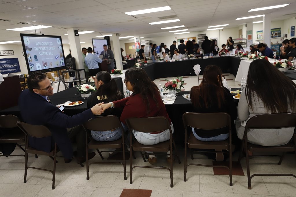 Student in the Superintendent Student Advisory Council shakes hands with Superintendent Dr. Brian Lusk during meeting