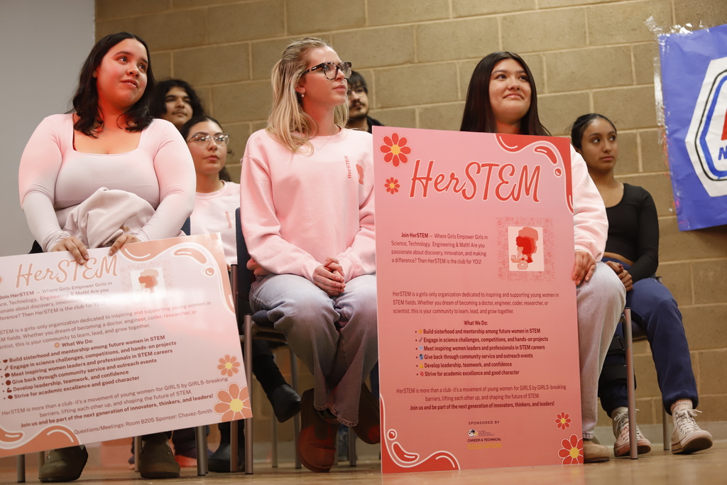 HerSTEM initiative members smile while listening to speaker