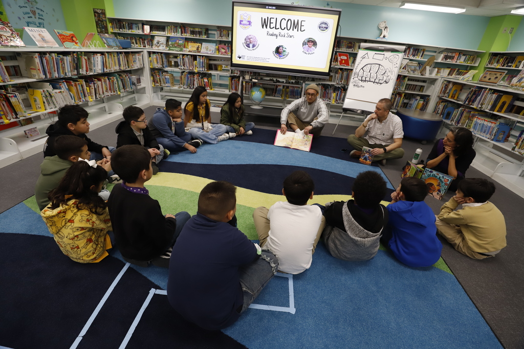 Cooley Elementary students sit in a circle with during an  authors and illustrators visit