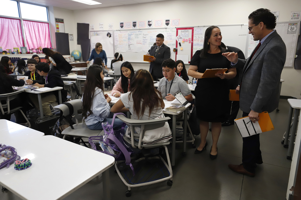 Superintendent Dr. Brian Lusk talks with Bowie High School principal in classroom with students