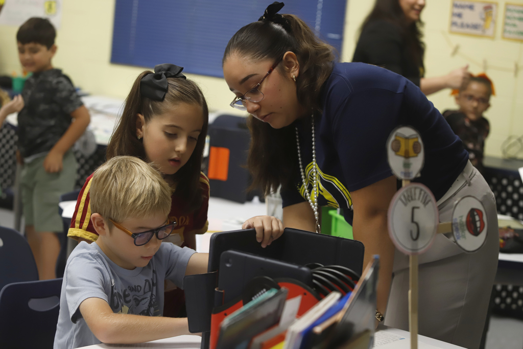 El Paso ISD teacher helping two students